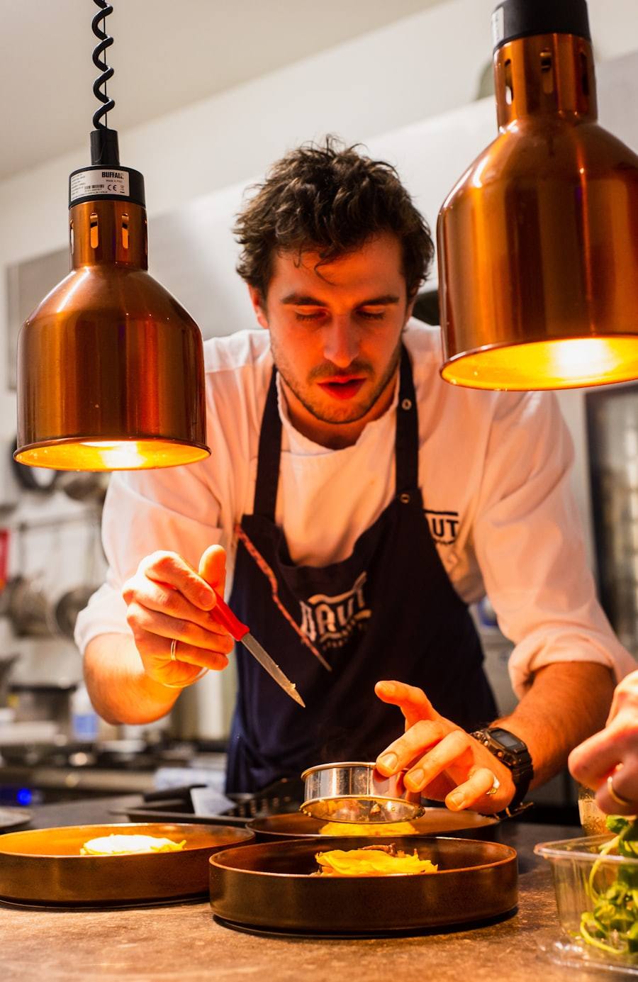 A chef plating a dish with care