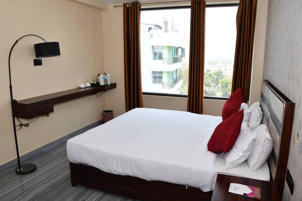 Business Class Room at Chinmaye Inn — bed by the window with work ledge